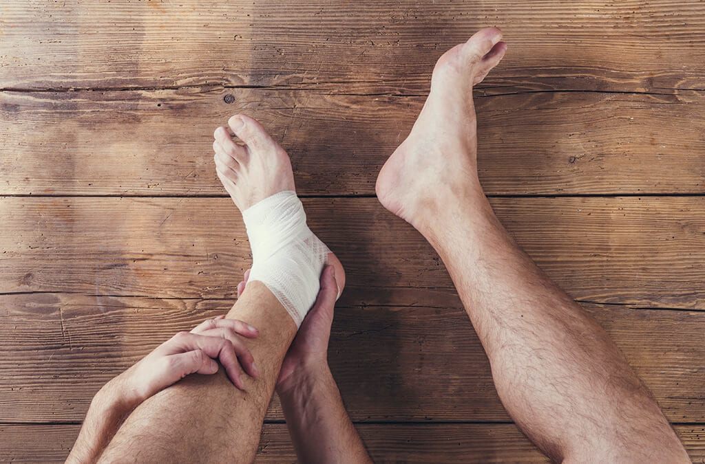 Man holding his leg with bandage on foot