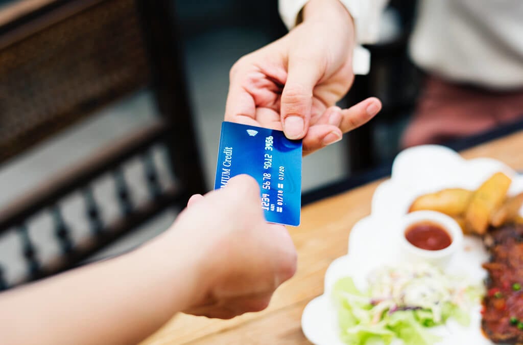 El cliente paga al cajero con tarjeta de crédito en el restaurante