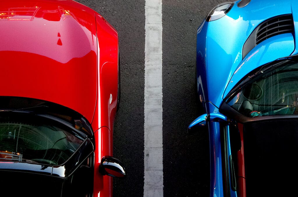 Blue and red cars side by side in parking lot