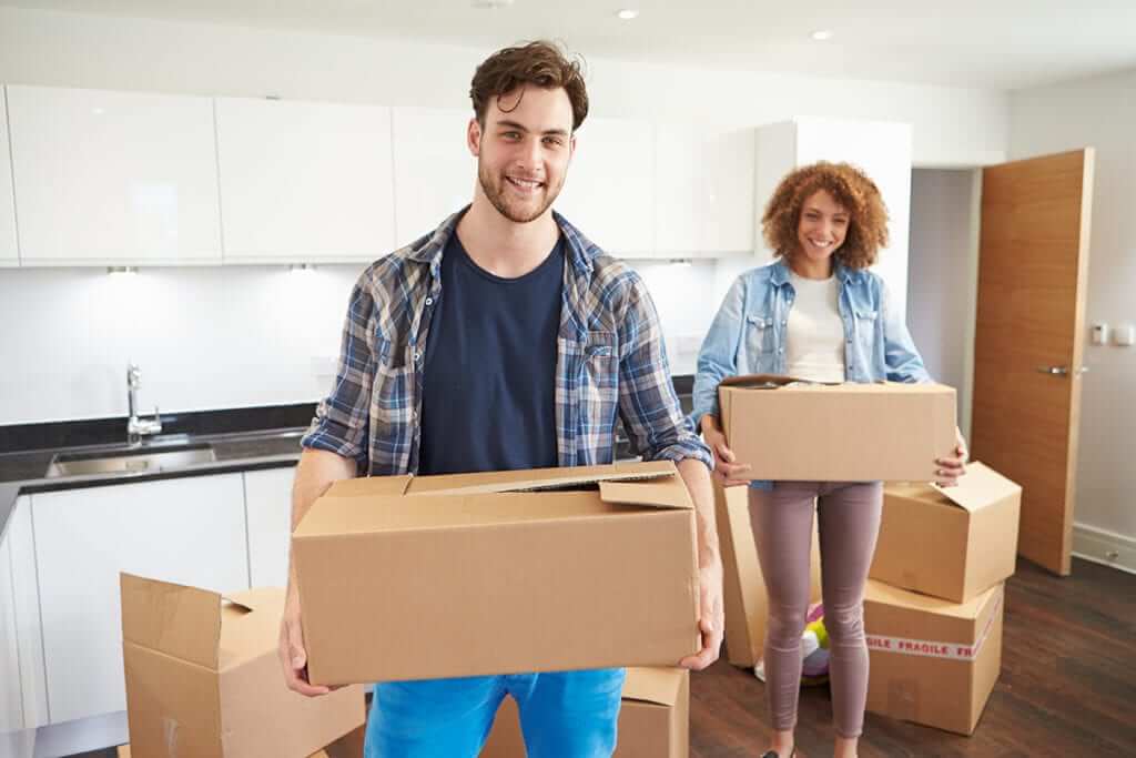 Couple moving boxes into new home