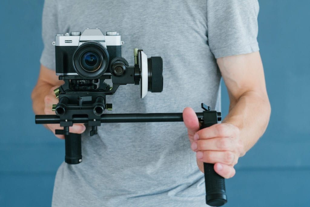 moderne technik für videodrehs. mann mit kamerahalter. ausrüstung und werkzeuge für das erstellen von blogs und footage-inhalten.