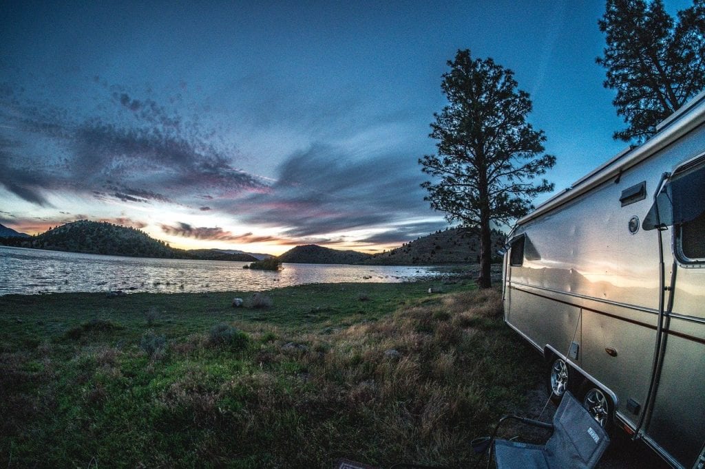 airstream on a lake with a sunset in the background