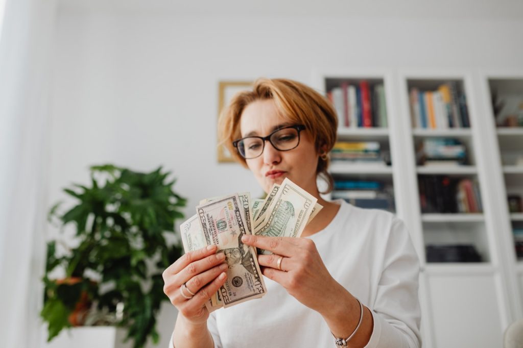 woman looking at her money as she counts it